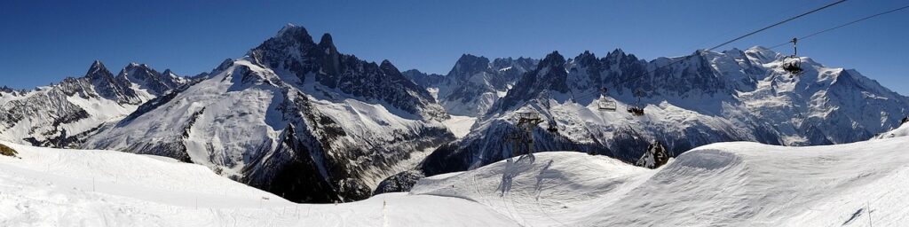 Vue panoramique de la station de ski des 2 Alpes, avec ses pistes enneigées et ses montagnes majestueuses, idéale pour les skieurs et les snowboardeurs